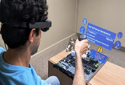 Technician using an AR headset to follow guided work instructions over a real circuit board